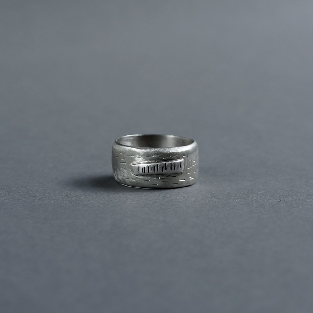 Melanie Decourcey / Wide heavy silver ring with vertical lines and horizontal lines in center