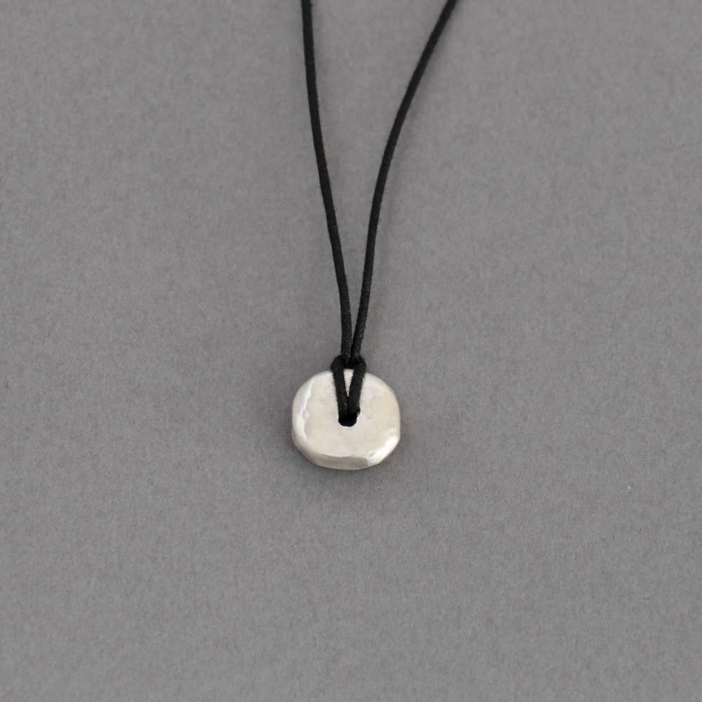 Melanie Decourcey / pendant on string / round free style hammerd disc 