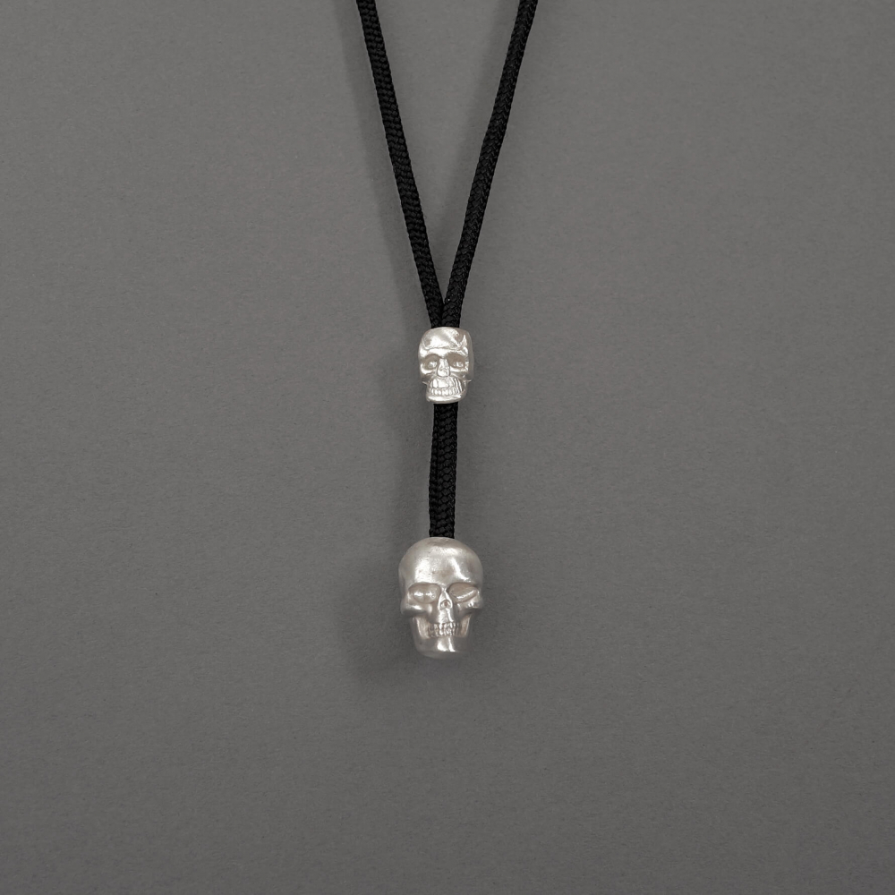 Melanie Decourcey / pendant on string / double skull pendant